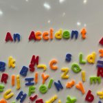 An Accident is spelt in bright magnetic letters on a whiteboard.