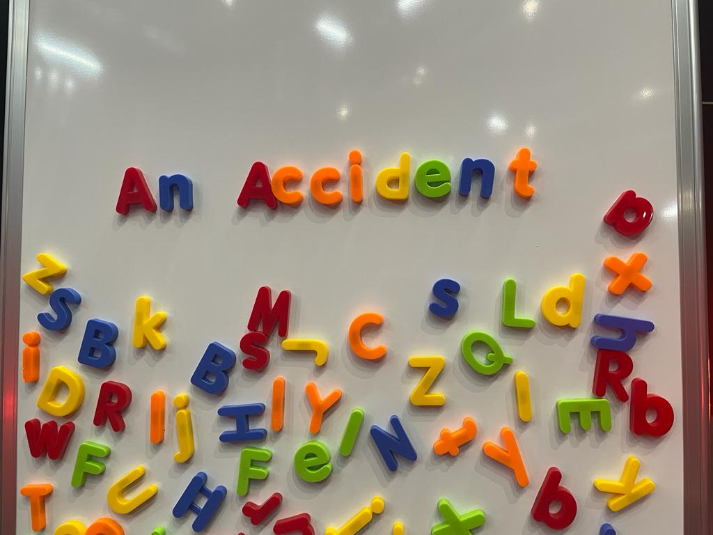 An Accident spelt in bright magnetic letters on a whiteboard.
