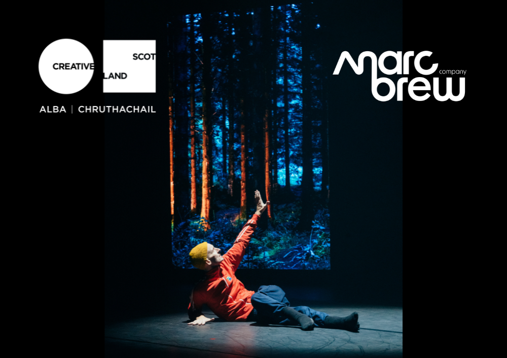 Marc Brew is lying on the floor with his chest raised, his weight on his leg arm, while his right arm reaches to the sky. An image of trees in a forest is behind him. The creative Scotland Logo in white and the Marc Brew Company logo in white are in both top corners.