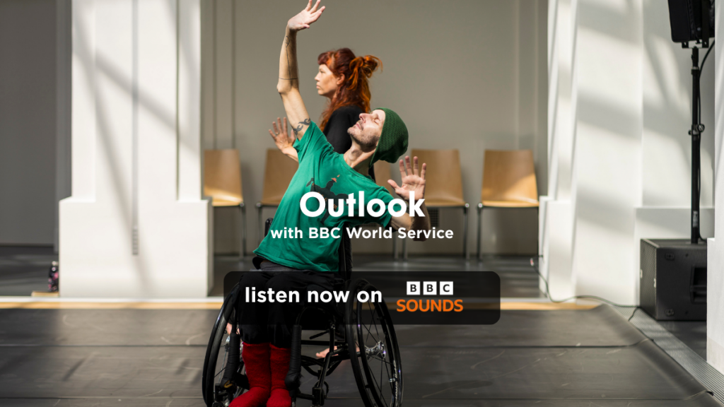 An image of Marc Brew in his wheelchair in mid movement. reads “Outlook with BBC world service, listen on BBC sounds. Listen now!”
